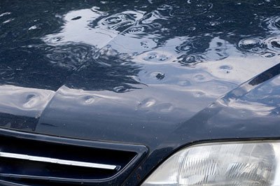 car with hail damage on hood